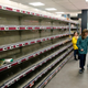 Grocery shoppers surrounded by empty shelves